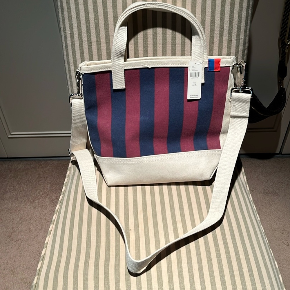 Kule striped canvas bucket bag in red and navy and cream, with cross body strap.